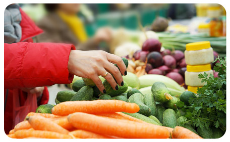 Hand choosing vegetables at the farmers market